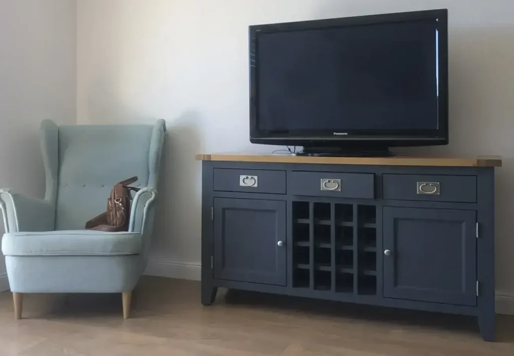 Masívna čierna komoda pod televízor s priestorom pre vínové fľaše u našej zákazníčky.